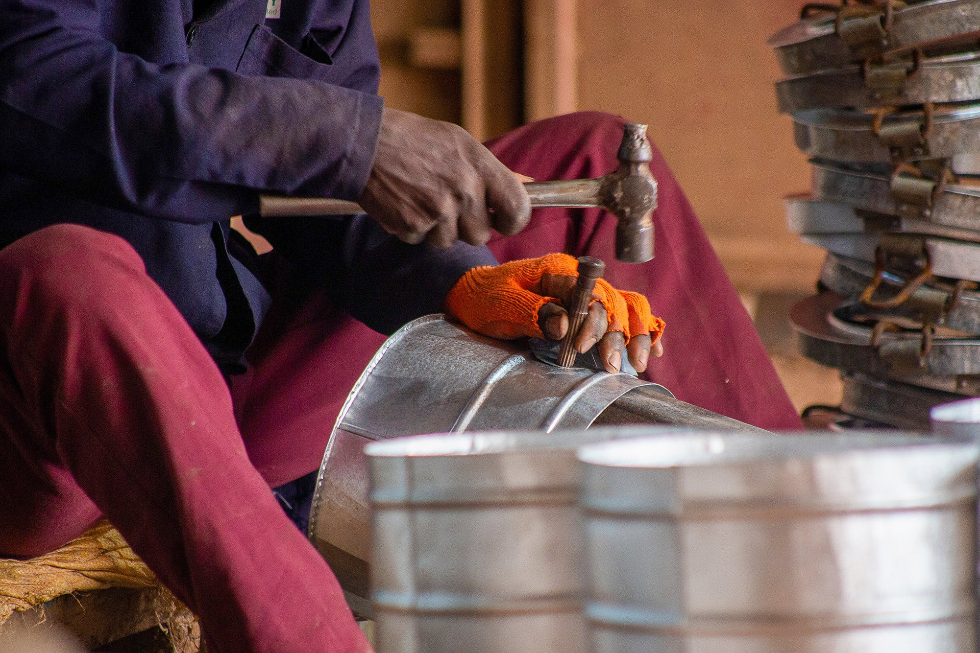 A craftsman assembling an improved cookstove